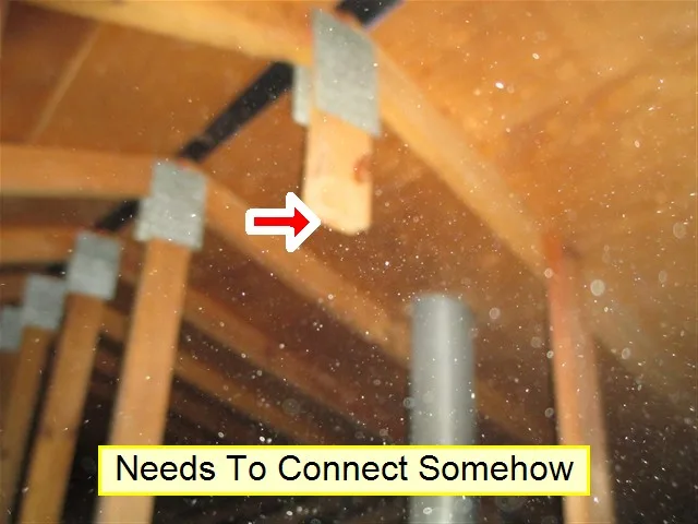 Attic trusses with a red arrow at a cut truss member