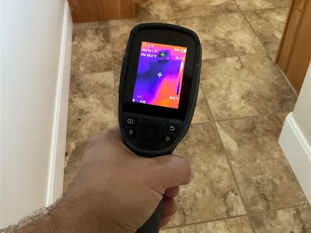 Thermal camera held over a tile bathroom floor