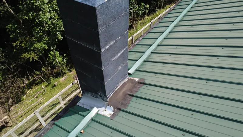 Drone photo of chimney flashing on a green metal roof