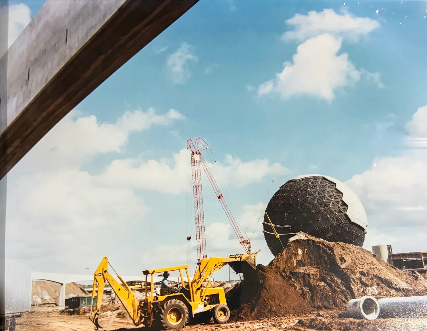 Vintage photo of a backhoe grading beside Epcot's Spaceship Earth during construction